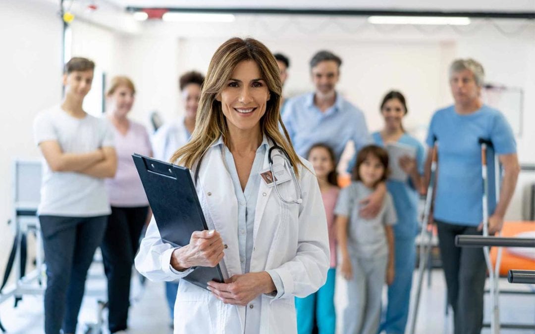 Doctor-standing-with-group-of-patients-behind-her